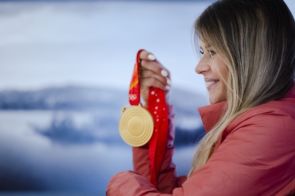 Olympia Goldmedaillengewinnerin Corinne Suter posiert bei ihrer Ankunft am Flughafen Zuerich mit der Goldmedaille, am Mittwoch, 16. Februar 2022 in Zuerich Kloten. (KEYSTONE/Michael Buholzer)