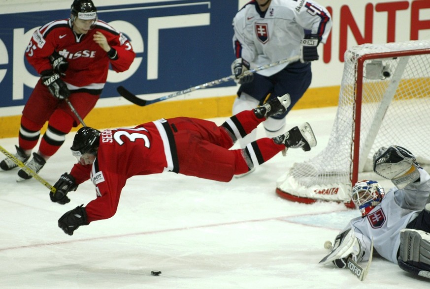 Der slovakische Torhueter Jan Lasak, rechts, laesst den Schweizer Mathias Seger fliegen, beobachtet von seinem Mitspieler Sandy Jeannin, hinten, im Viertelfinalspiel zwischen der Slovakei und der Schw ...