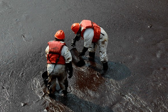 epa09709354 Workers carry out a cleaning operation on the beaches of Ventanilla, Peru, 25 January 2022. The Repsol company stated that it is &#039;closely collaborating&#039; with civil society and th ...