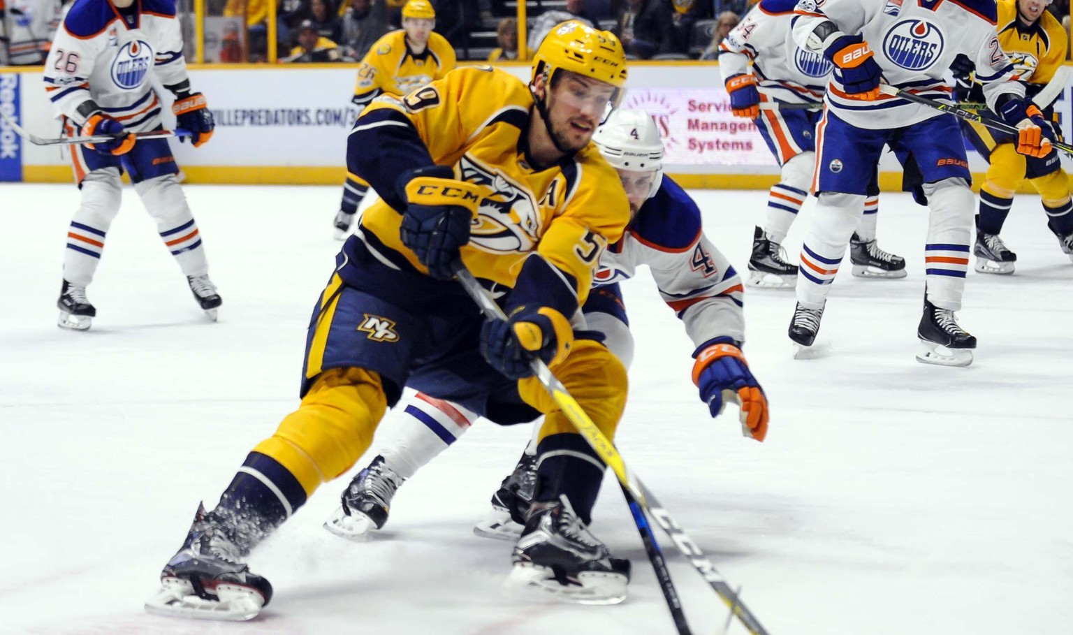 Feb 26, 2017; Nashville, TN, USA; Nashville Predators defenseman Roman Josi (59) fights for the puck with Edmonton Oilers defenseman Kris Russell (4) during the first period at Bridgestone Arena. Mand ...