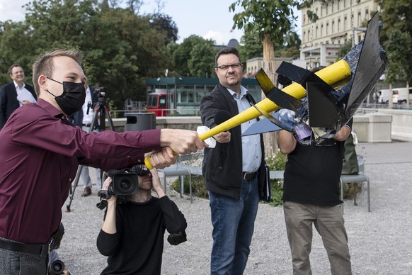 Jonas Kampus, GSoA, zerstoert eine Attrappe eines Kampffliegers bei der Lancierung der Stop F-35 Initiative, am Dienstag, 31. August 2021, in Bern. (KEYSTONE/Peter Schneider)