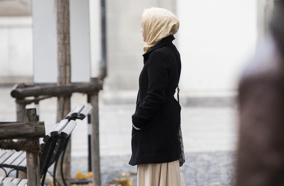 Ein junge Frau mit Kopftuch verweilt vor dem St. Galler Verwaltungsgericht anlaesslich der Gerichtsverhandlung zum Kopftuchverbot im Schulunterricht am Freitag, 7. November 2014, in St. Gallen. Das St ...