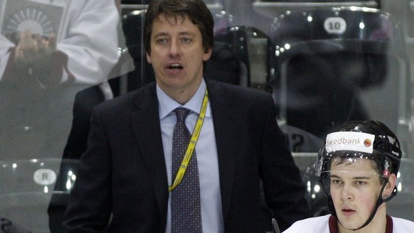 Harijs Vitolins, assistant coach of Latvia national ice hockey team, speaks with his players, in the Group C Preliminary Round game between Austria and Latvia at the IIHF 2009 World Championship at th ...