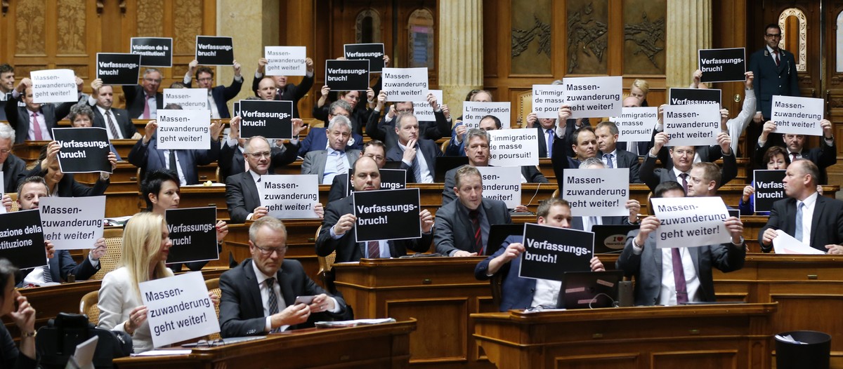 Mitglieder der SVP halten Plakate mit der Aufschrift "Verfassungsbruch" hoch, bei der Schlussabstimmung ueber die Masseneinwanderungsinitiative im Nationalrat, waehrend der Wintersession der ...