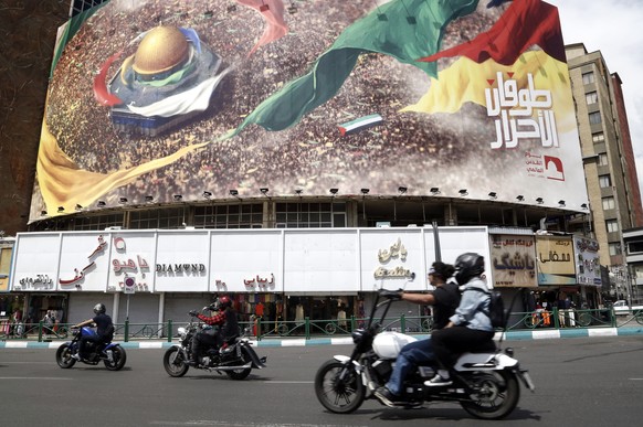 epa11274435 Iranians pass an anti-Israel billboard in Tehran, Iran, 12 April 2024. According to the Iranian supreme leader&#039;s official website, Khamenei said on 10 April that Israel &#039;should b ...