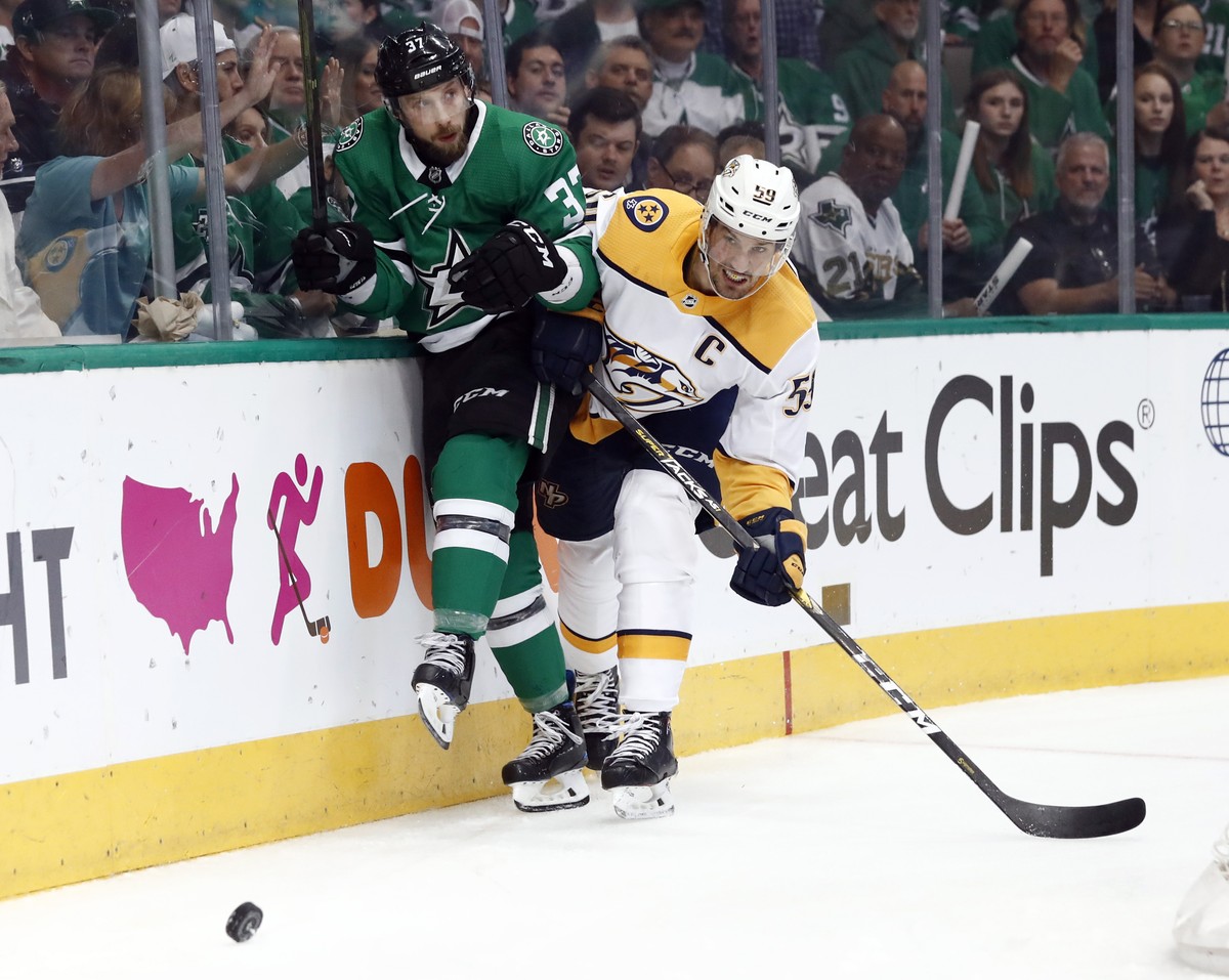Dallas Stars' Justin Dowling (37) and Nashville Predators' Roman Josi (59) slam against the boards chasing after the puck in the first period of Game 6 in an NHL hockey first-round playoff s ...