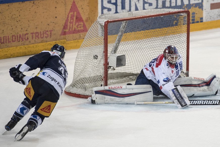 Carl Klingberg, links, von Zug schiesst das 3:0 gegen Torhueter Lukas Flueeler, rechts, vom ZSC im ersten Eishockey Playoff-Viertelfinalspiel der National League zwischen dem EV Zug und den ZSC Lions, ...