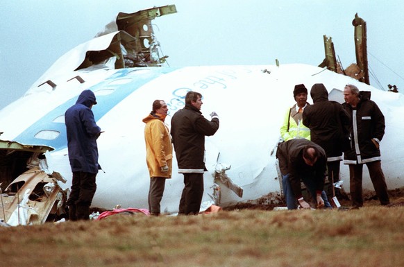 FILE - Unidentified crash investigators inspect the nose section of the crashed Pan Am flight 103, a Boeing 747 airliner in a field near Lockerbie, Scotland, Dec. 23, 1988. The plane crashed two days  ...