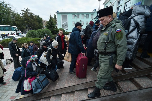 epa10257303 Local people evacuated from Kherson arrive to railway station in Dzhankoy, Crimea, 21 October 2022, where temporary accomodation centers have been set up. Kherson Region acting Governor Sa ...