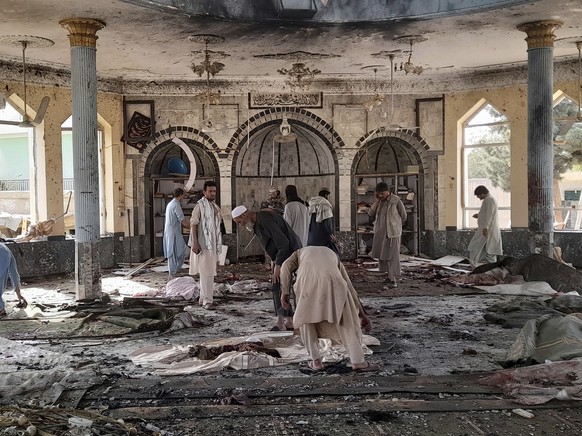 People view the damage inside of a mosque following a bombing in Kunduz, province northern Afghanistan, Friday, Oct. 8, 2021. A powerful explosion in the mosque frequented by a Muslim religious minori ...