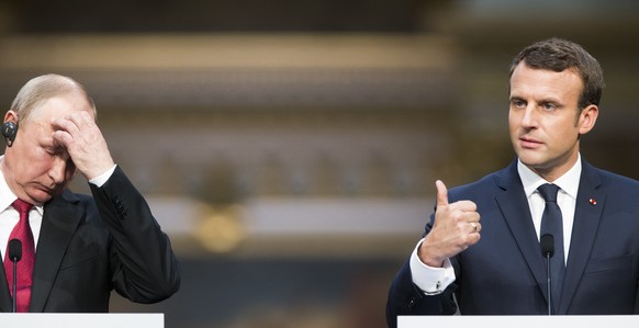 French President Emmanuel Macron, right, and his Russian counterpart Vladimir Putin hold a joint press conference at the Palace of Versailles as they meet for talks before the opening of an exhibition ...