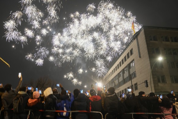 Spectators at the boulevard Unter den Linden watch fireworks as they celebrate the New Year near the Brandenburg Gate in Berlin, Germany, Saturday, Jan. 1, 2022. Large-scale New Year celebrations are  ...