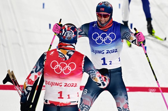 epa09761642 Johannes Hoesflot Klaebo (R) of Norway celebrates with teammate Erik Valnes after winning the Men's Team Sprint final at the Zhangjiakou National Cross-Country Skiing Centre at the Beijing 2022 Olympic Games, Zhangjiakou, China, 16 February 2022.  EPA/VASSIL DONEV