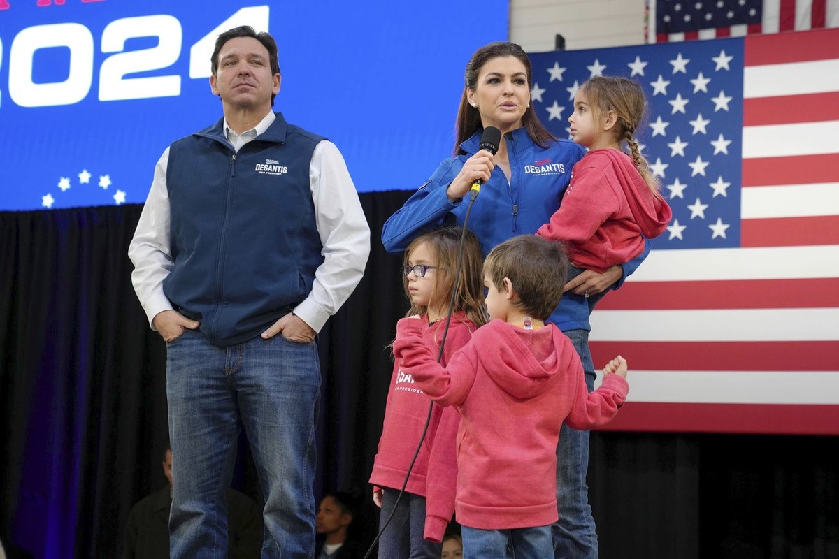 FILE - Republican presidential candidate Florida Gov. Ron DeSantis, left, looks on as his wife Casey DeSantis, carrying daughter Mamie, speaks during a campaign event at The Hangout on Saturday, Jan.  ...