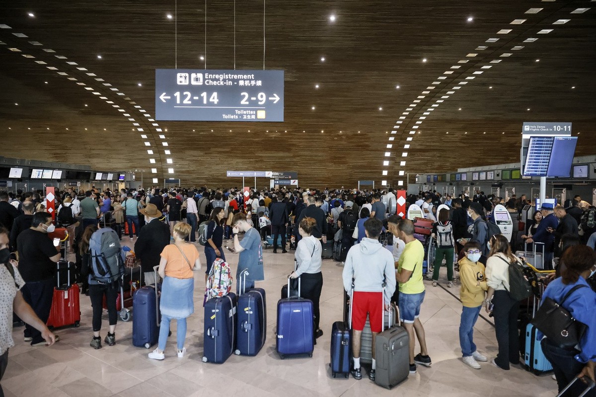 Des passagers attendent de s'enregistrer dans un terminal de l'aéroport Charles de Gaulle, le vendredi 1er juillet 2022 à l'aéroport de Roissy, au nord de Paris. Les vols depuis l' ...