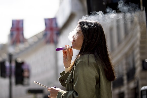 epa10663280 A person uses a vape product in London, Britain, May 30, 2023. The British government has announced a crackdown on retailers providing free vape samples to children.  Government...