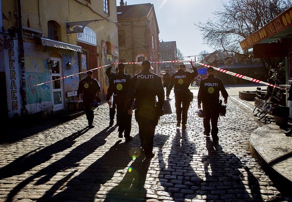epa04123633 Danish police patrol a neighbourhood during a raid at the freetown Christiania community in Copenhagen, Denmark, 13 March 2014. In the first largest raid of its kind to date against marihu ...