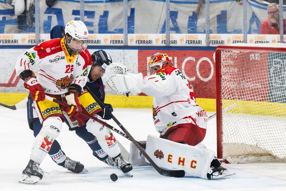 From left, Johnny Kneubuehler (EHCB), Andre Heim (HCAP) and goalkeeper Harri Saeteri (EHCB), during the regular season of National League A (NLA) Swiss Championship 2024/25 between HC Ambri Piotta and ...