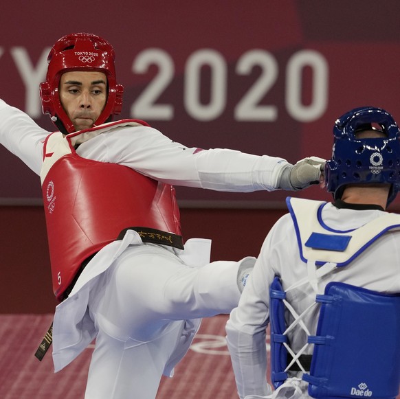 Tonga's Pita Taufatofua, left, attacks Slovenia's Ivan Trajkovic during the taekwondo men's 80kg match at the 2020 Summer Olympics, Tuesday, July 27, 2021, in Tokyo, Japan. (AP Photo/Th ...