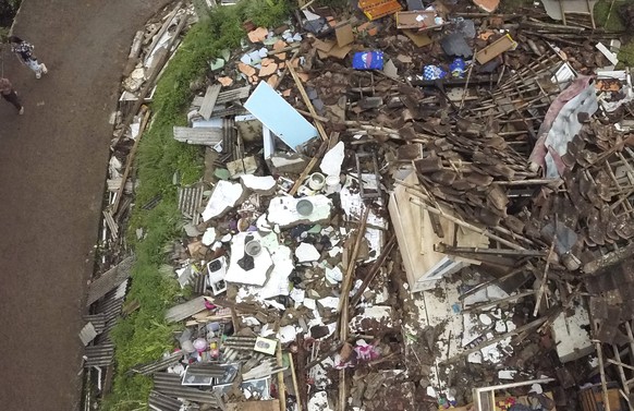 Villagers walk by what was a house before it was destroyed following an earthquake in this aerial photo at Suka Mulya village in Cianjur, West Java, Indonesia, Saturday, Nov. 26, 2022. The magnitude 5 ...