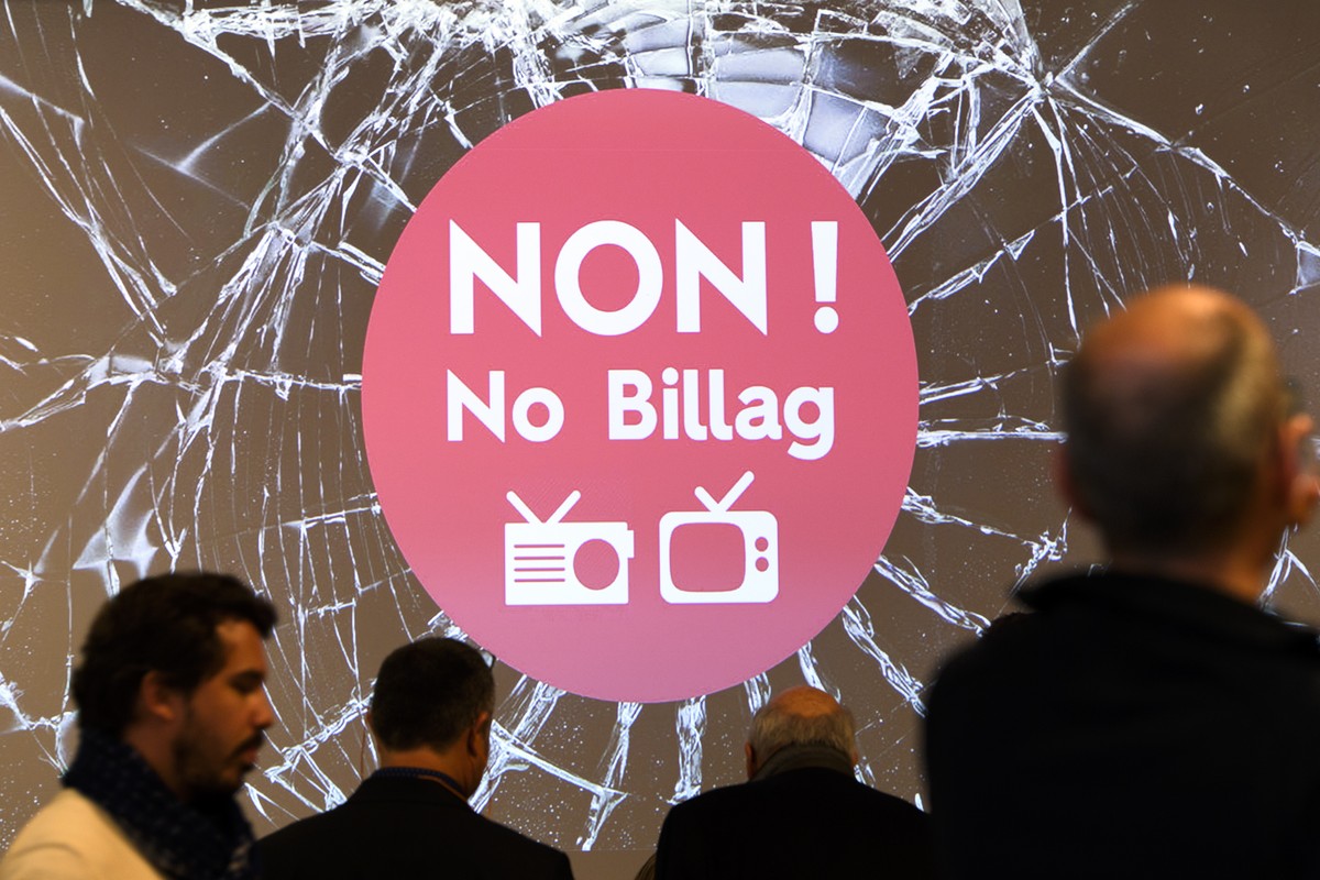 Des journalistes marchent devant un logo Non ! No Billag lors de la conference de presse de l'Association contre la disparition des radios et TV, NON a No Billag ce jeudi 2 novembre 2017 a Lausan ...