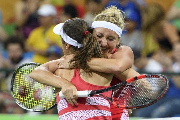 epa05460607 Timea Bacsinszky, right, and Martina Hingis, left, of Switzerland celebrate the victory after the womenÃs first round doubles match against Daria Gavrilova and Samantha Stosur from Austra ...