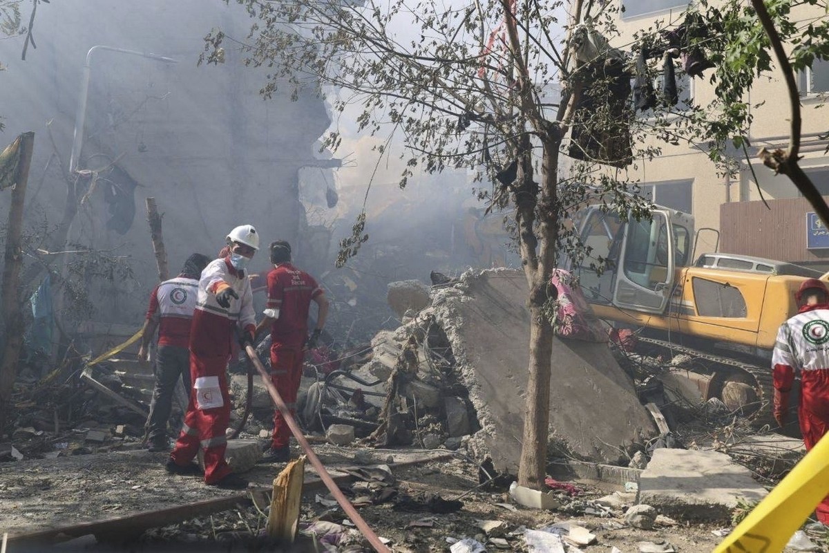 In this photo released by the Iranian Red Crescent Society rescuers work at the scene of an explosion after an Israeli strike in Tehran, Iran, Friday, June 13, 2025. (Iranian Red Crescent Society via  ...