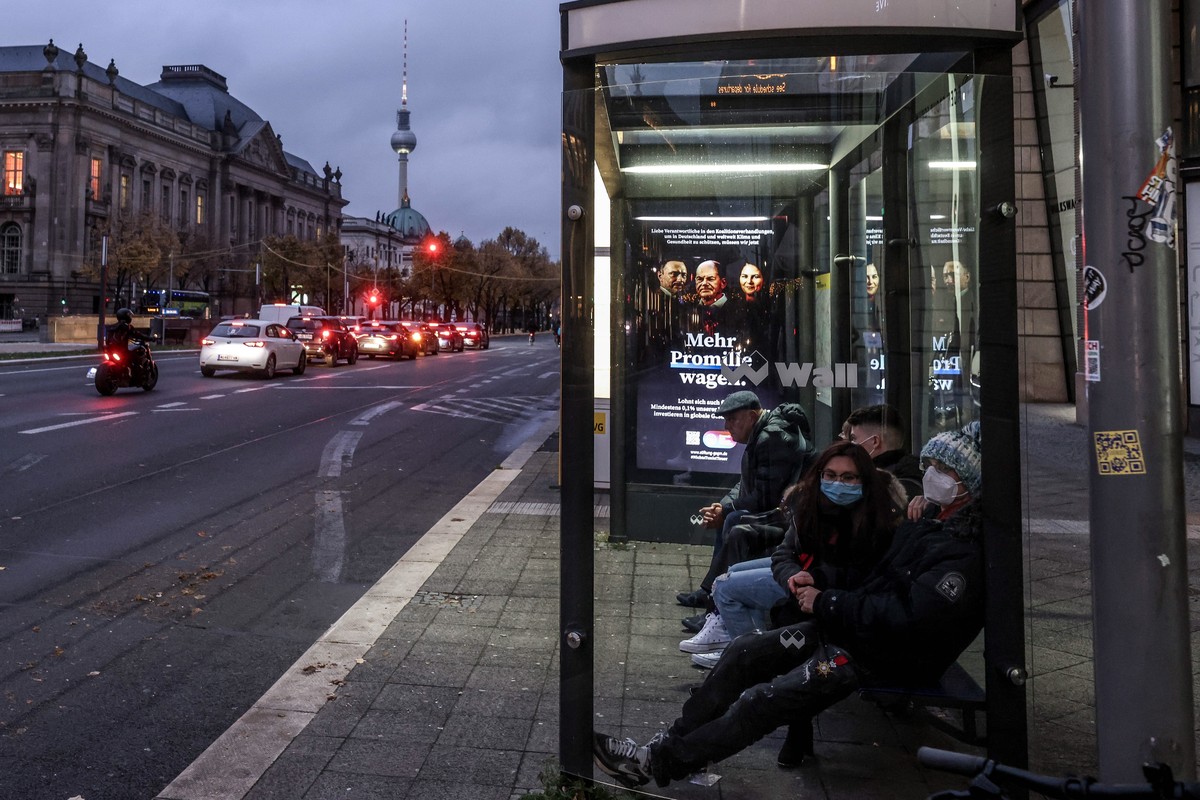 epa09566461 People wear face mask as they wait at bus stop in central Berlin, Germany, 05 November 2021. Due to an increasing number of cases of the pandemic COVID-19 disease caused by the corona viru ...
