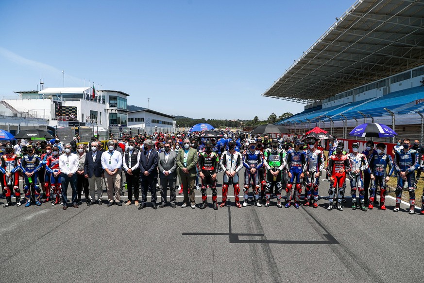 epa09237043 World Superbike riders line up in the pit lane to pay tribute to Swiss Moto3 rider Jason Dupasquier, who died today after a crash sustained yesterday in the training session for the Motorc ...