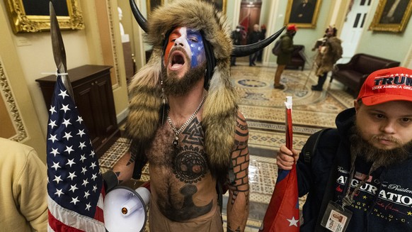 Jacob Anthony Chansley, center, with other insurrectionists who supported then-President Donald Trump, are confronted by U.S. Capitol Police in the hallway outside of the Senate chamber in the Capitol ...