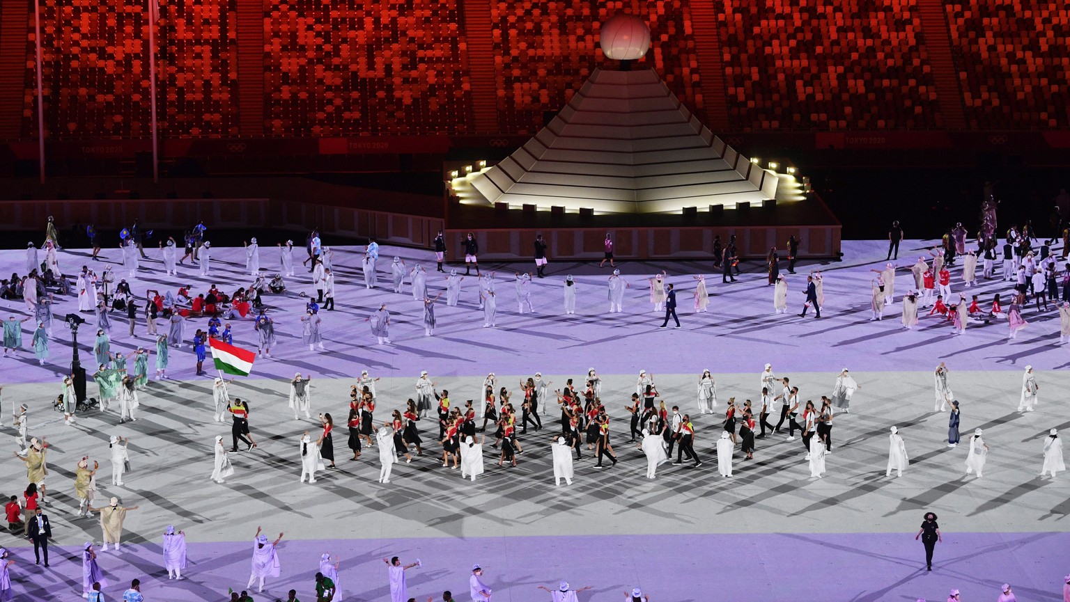 epa09359855 Foil fencer Aida Mohamed and swimmer Laszlo Cseh carry the national flag as the team of Hungary parades during the opening ceremony of the Tokyo 2020 Olympic Games in the Olympic Stadium i ...