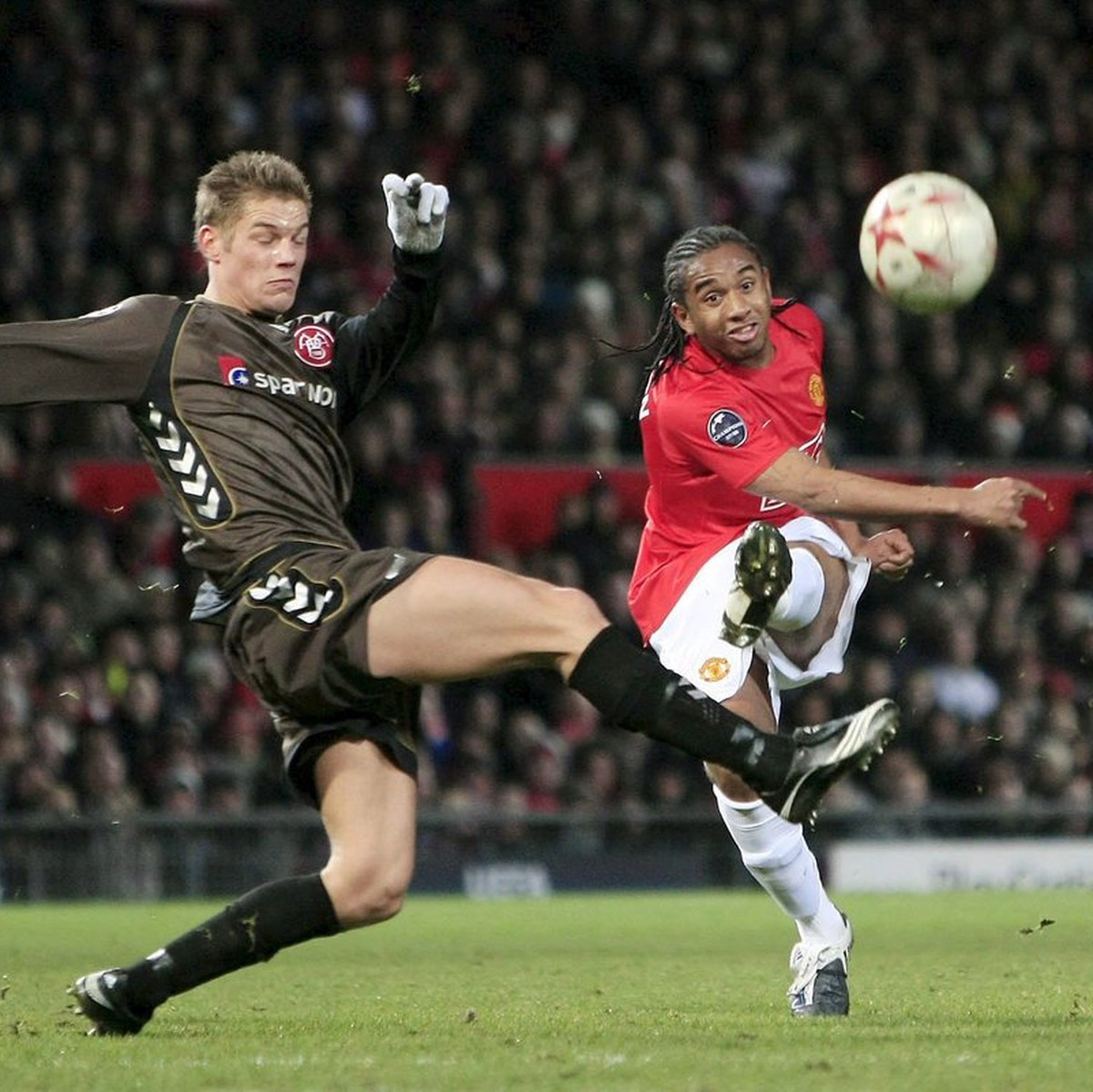 epa01574036 Aalborg's Michael Jakobsen (L) tries to block a shot by and Manchester United's Anderson during the Champions League match between Manchester United and Aalborg at Old Trafford,  ...