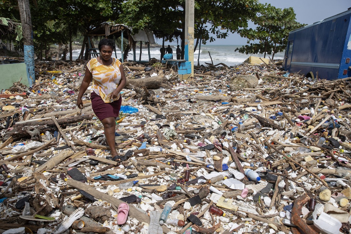 epa11455967 A woman walks along the beach of Manresa, covered with garbage after the passage of Hurricane Beryl, in Santo Domingo, Dominican Republic, 3 July 2024. The Dominican Republic and Haiti eme ...