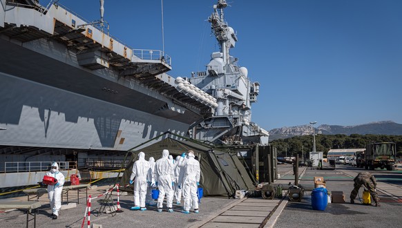 epa08367136 A handout photo made available by the French Defense Ministry on 16 April 2020 shows officers getting prepared to work on cleaning and disinfecting the French nuclear aircraft carrier Char ...