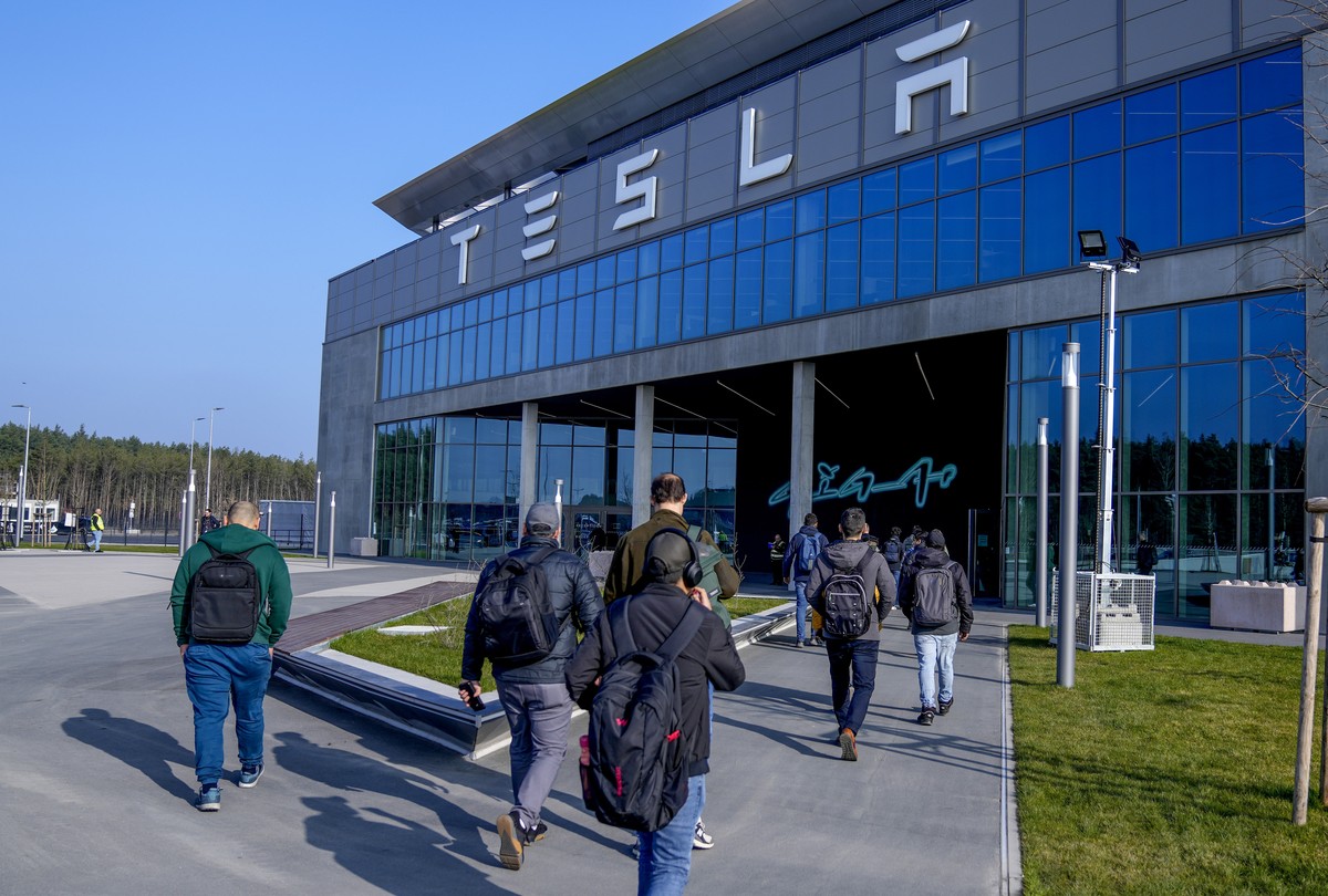 FILE - People walk to the Tesla Gigafactory for electric cars in Gruenheide near Berlin, Germany,March 13, 2024. After reporting dismal first-quarter sales, Tesla is planning to lay off about a tenth  ...