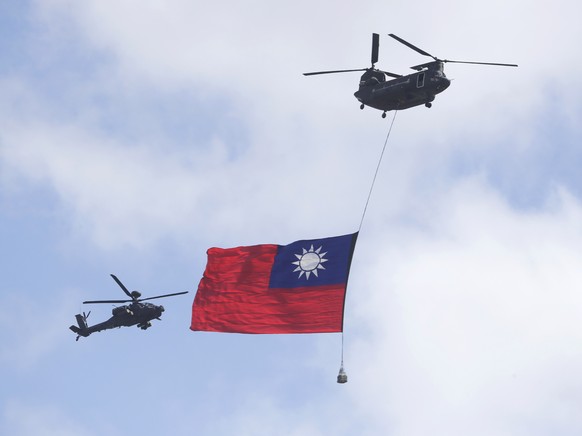 Helicopters fly over President Office with Taiwan National flag during National Day celebrations in front of the Presidential Building in Taipei, Taiwan, Sunday, Oct. 10, 2021. (AP Photo/Chiang Ying-y ...