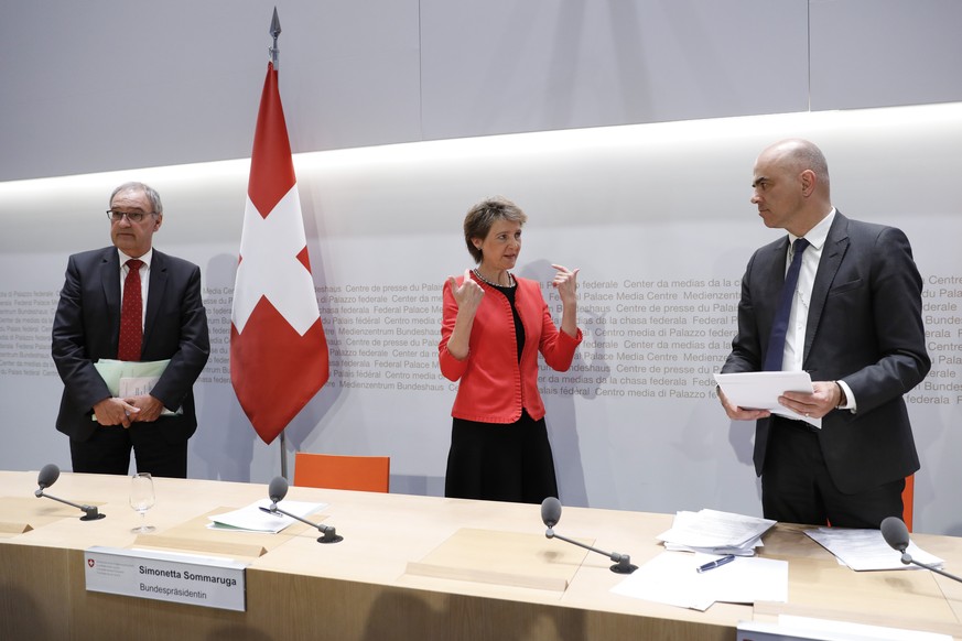 Bundesrat Alain Berset, rechts, diskutiert mit Bundespraesidentin Simonetta Sommaruga und Bundesrat Guy Parmelin, am Ende einer Medienkonferenz des Bundesrates ueber die Situation des Coronavirus, am  ...