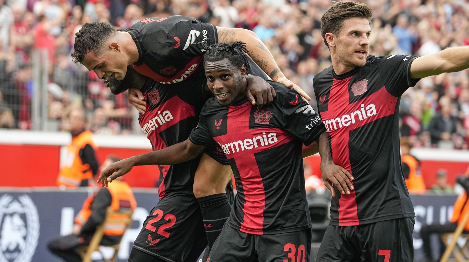 Leverkusen&#039;s Jeremie Frimpong celebrates after scoring his side&#039;s second goal with Victor Boniface, left, Jonas Hofmann, right, and Granit Xhaka, up, during the German Bundesliga soccer matc ...