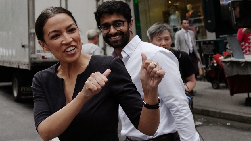Alexandria Ocasio-Cortez, the winner of a Democratic Congressional primary in New York, reacts to a passerby, Wednesday, June 27, 2018, in New York. Ocasio-Cortez, 28, upset U.S. Rep. Joe Crowley in T ...