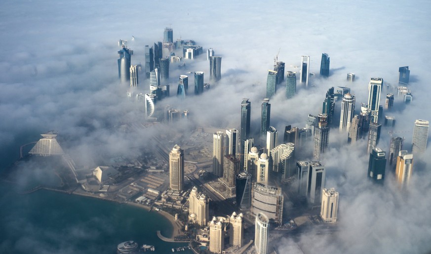 epa06011227 (FILE) - An aerial view of high-rise buildings emerging through fog covering the skyline of Doha, as the sun rises over the city, in Doha, Qatar, 15 February 2014 (reissued 05 June 2017).  ...