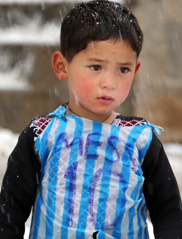 In this Friday, Jan. 29, 2016 photo, Murtaza Ahmadi, a five-year-old Afghan Lionel Messi fan plays football near his home, in the Jaghori district of Ghazni in Afghanistan. The Afghan Football Federat ...