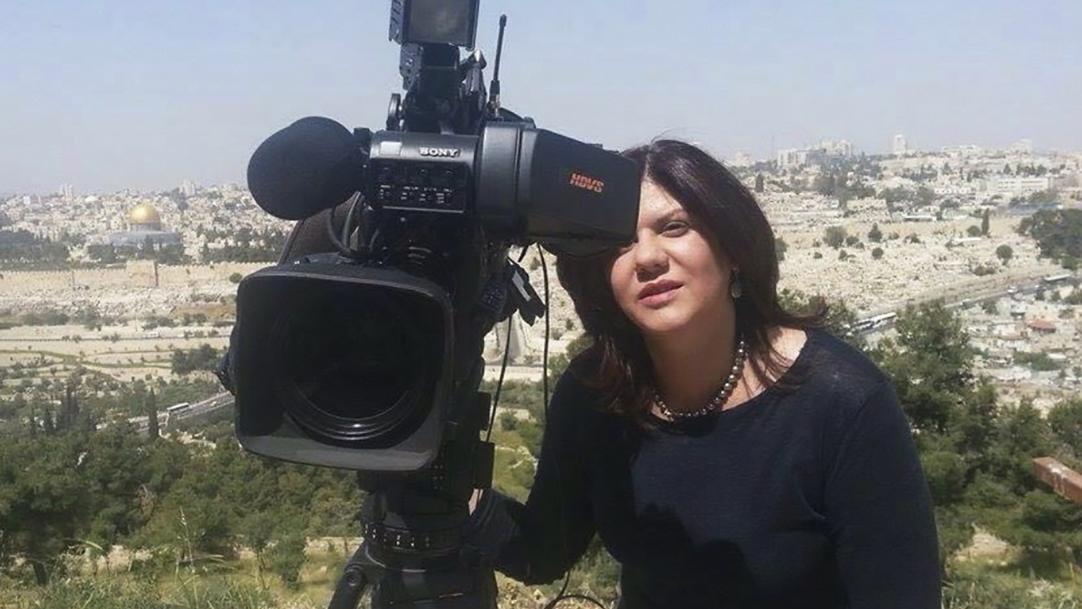 In this undated photo provided by Al Jazeera, Shireen Abu Akleh, a journalist for Al Jazeera network, stands next to a TV camera in an area where the Dome of the Rock shrine at Al-Aqsa Mosque in the O ...