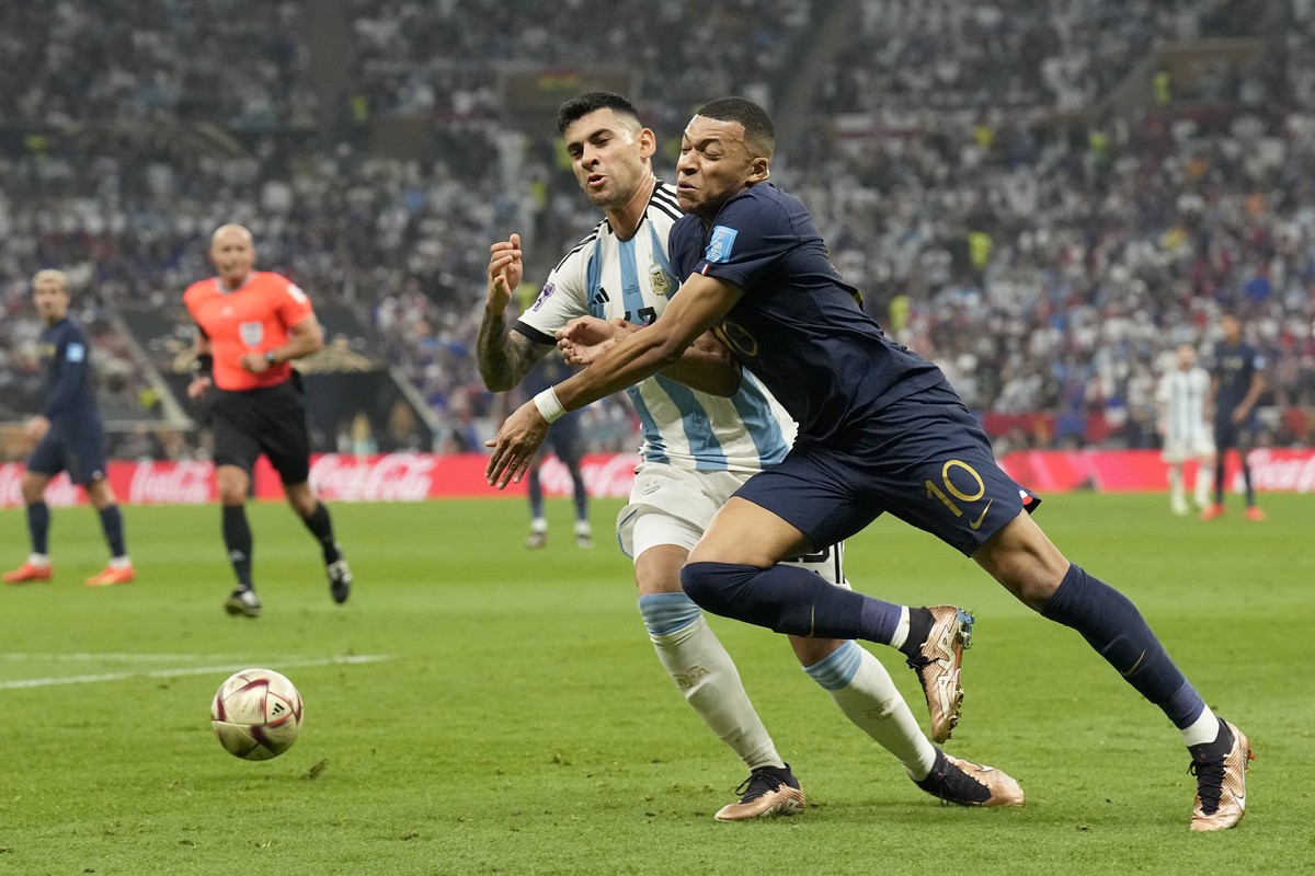 France's Kylian Mbappe, right, tries to get past Argentina's Cristian Romero during the World Cup final soccer match between Argentina and France at the Lusail Stadium in Lusail, Qatar, Sund ...