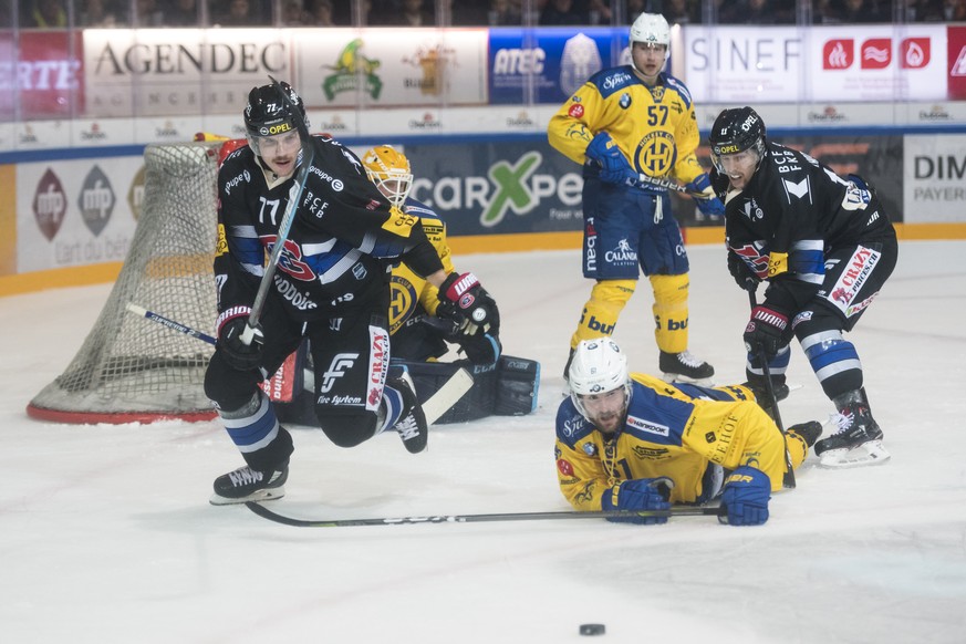 Le defenseur fribourgeois Sebastian Schilt, gauche, lutte pour le puck avec l&#039;attaquant davosiens Fabian Heldner, centre, et l&#039;attaquant fribourgeois Lukas Lhotak, droite, lors de la rencont ...