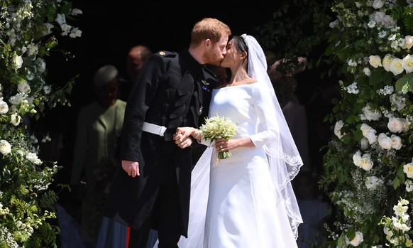 epaselect epa06749566 Britain's Prince Harry (L), Duke of Sussex and Meghan (R), Duchess of Sussex kiss as they exit St George's Chapel in Windsor Castle after their royal wedding ceremony, ...