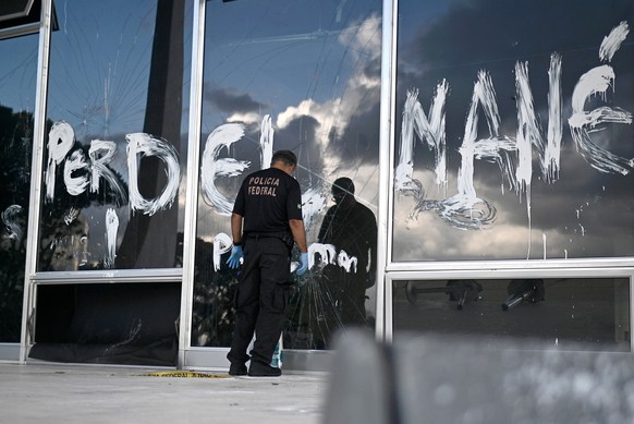 epaselect epa10399264 A federal police officer watches the destruction at Supreme Court headquarters after the January 8 protests in Brasilia, Brazil, January 10, 2023. Broken glass, dest...