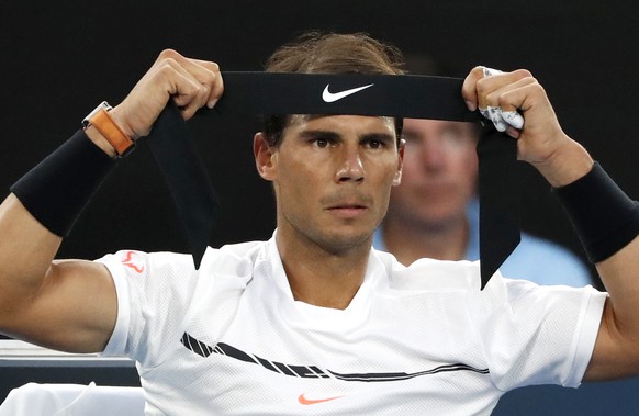 Spain&#039;s Rafael Nadal prepares to tie a headband during a break in his semifinal against Bulgaria&#039;s Grigor Dimitrov at the Australian Open tennis championships in Melbourne, Australia, Friday ...