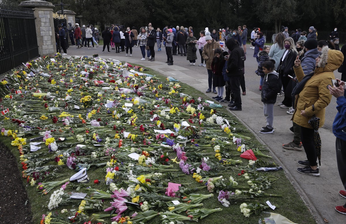People look at flowers outside Windsor Castle in Windsor, England Sunday, April 11, 2021. Britain's Prince Philip, the irascible and tough-minded husband of Queen Elizabeth II who spent more than ...