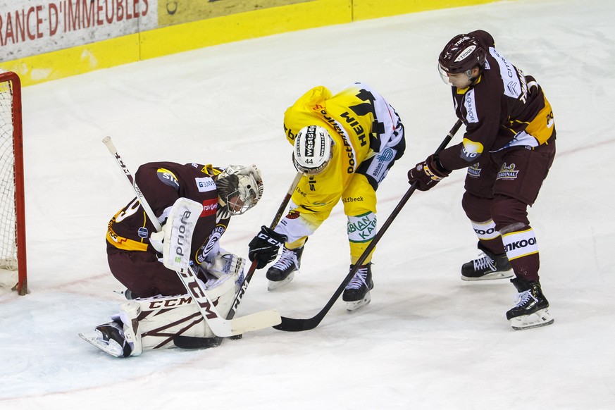 Geneve-Servette&#039;s goaltender Robert Mayer, left, saves a puck past Bern&#039;s center Andre Heim #44 and Geneve-Servette&#039;s defender Henrik Toemmernes, of Sweden, right, during a National Lea ...