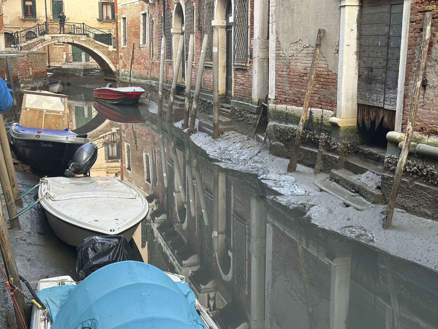 Boats are docked on a dry canal during a low tide in Venice, Italy, Monday, Feb. 20, 2023. (AP Photo/Luigi Costantini)